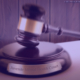 image of a judge's gavel resting on its podium on a desk with a placard on it that reads "Juvenile Mental Health Court". Behind the desk is a simple wood paneled wall. The entire image is somewhat blurred except for the placard, and there is a purple hue over the whole image. in the top corner is a copyright symbol and the words "2023 Healthy Minds Consulting, all rights reserved".