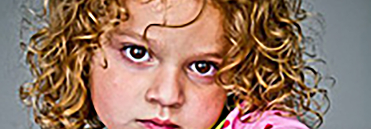 closeup of a young white child with curly blonde hair looking directly at the viewer.